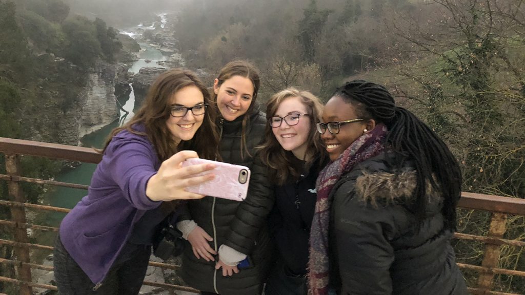 students take selfie on bridge in Italy